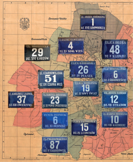Na Planie orientacyjnym stoł. król. miasta Krakowa wydanym przez Budownictwo Miejskie w 1925 r.
(pierwsze wydanie w 1916 r.) kolekcja zachowanych jeszcze na frontonach kamienic emaliowanych tabliczek
orientacyjnych z numerami domów według wzoru wprowadzanego sukcesywnie w okresie międzywojennym
(numeracja domów wprowadzona w 1881 r. co do zasady nie zmieniała się, podział na dzielnice katastralne
także był stabilny, stąd możliwość równoległego utrzymywania dawnego – jeszcze z roku 1881 – i nowego
wzoru tych tabliczek. Powyżej przedstawiono stan istniejący do roku 1941, kiedy to do granic