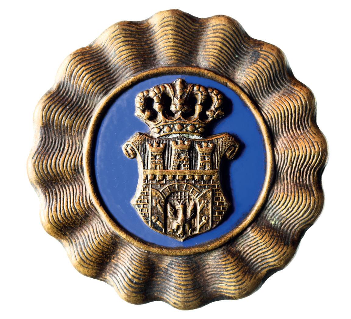 (027) Herb Krakowa umieszony na emalii barwy
szafirowej, wykonany w mosiądzu z odznaki czapkowej
krakowskiej Straży Obywatelskiej, formacji
wprowadzonej w 1917 r., u schyłku I wojny światowej;
jest to herb wedle wzoru utrwalonego już w okresie
autonomicznym (MK, nr inw. MHK 804/III)
